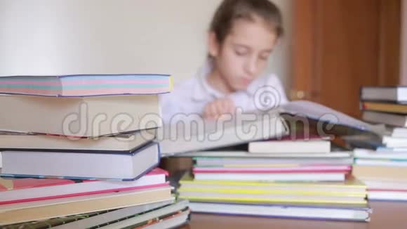 穿着校服的小女孩正在看书坐在成堆的书之间视频的预览图