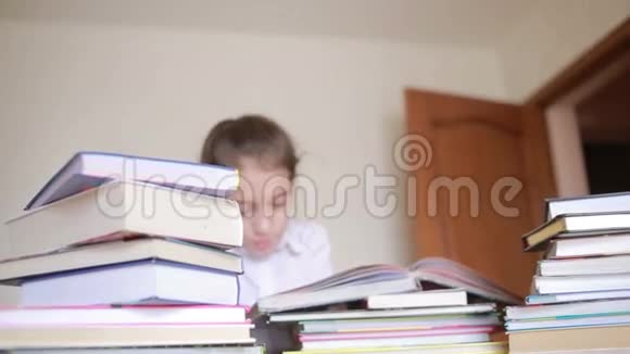 穿着校服的小女孩正在看书坐在成堆的书之间视频的预览图