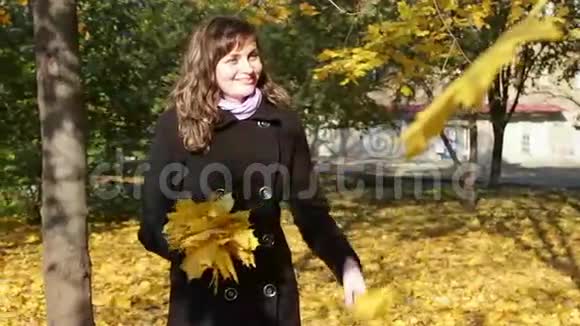 秋天公园的快乐女孩扔黄色的视频的预览图