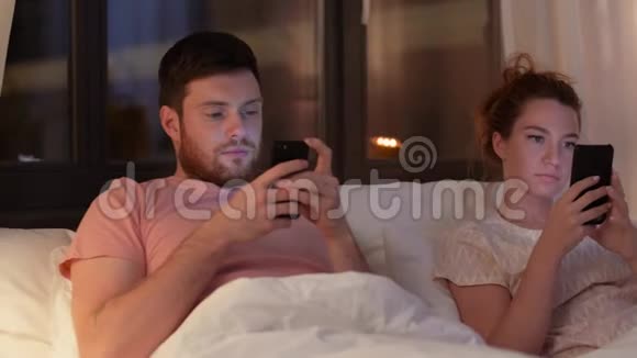 晚上在床上用智能手机的情侣视频的预览图