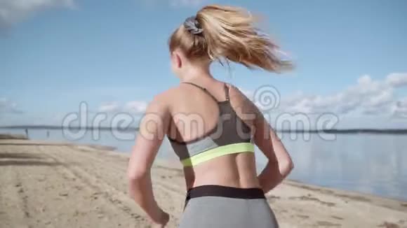 一个年轻的女孩沿着海岸奔跑视频的预览图
