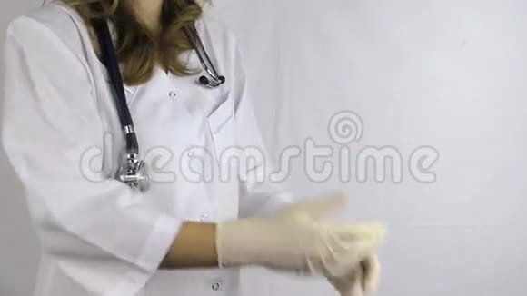 穿着听诊器工具的女医生脱下橡胶手套视频的预览图