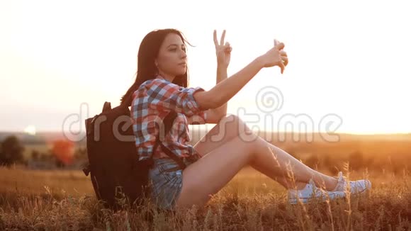 hipsterhiker剪影女孩旅行者休息慢动作视频与背包做自拍自画像旅行视频的预览图