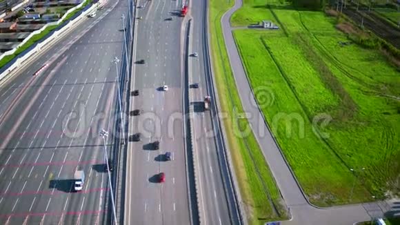 阳光明媚的夏日城市附近的现代高速公路立交桥的鸟瞰图视频的预览图