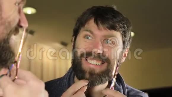 小帅哥用剪刀修剪胡须在美容院做胡子和造型的年轻人视频的预览图