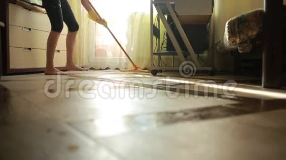 女人做清洁女孩打扫地板拖把清洁视频的预览图