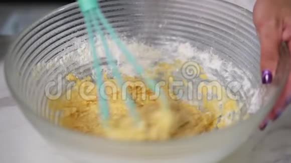 女性用搅拌器在厨房里搅拌面团自制食物慢镜头视频的预览图