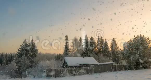 森林附近的一个小木屋夕阳下一场美丽的降雪一道美丽的冬季景观视频循环视频的预览图