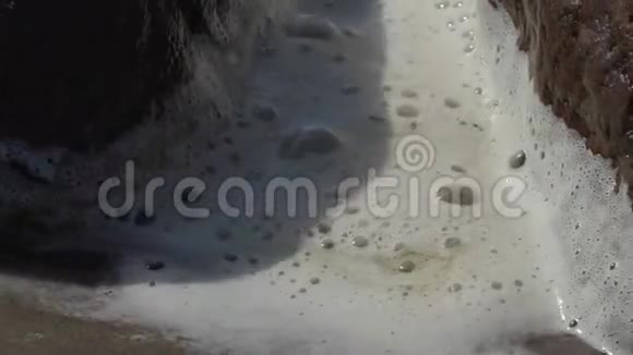 在夏季刮风的日子里海浪冲刷波罗的海沿岸的石头视频的预览图