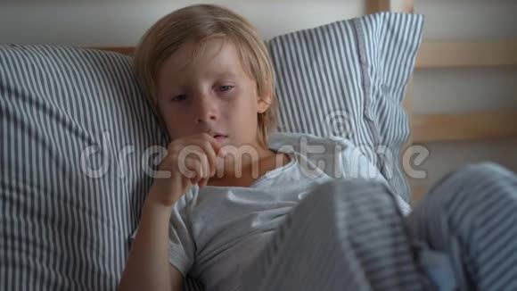在床上生病的小男孩男孩在床上咳嗽婴儿流感概念视频的预览图