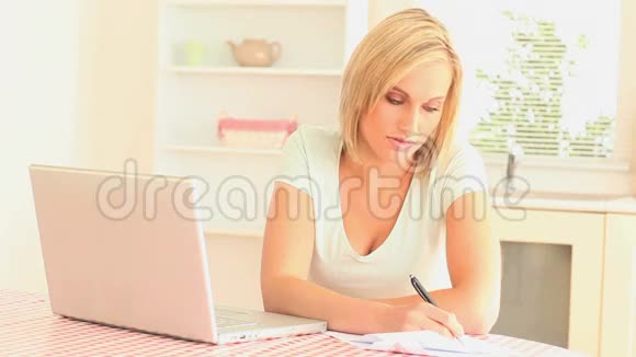 金发女性用她的笔记本电脑工作视频的预览图