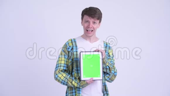 快乐的年轻帅哥展示数码平板电脑看上去很惊讶视频的预览图
