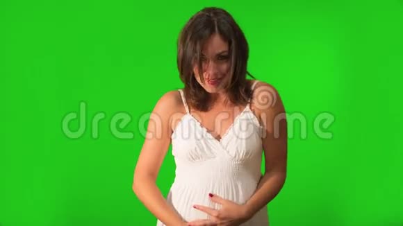幸福美丽的孕妇抱着她的肚子微笑视频的预览图