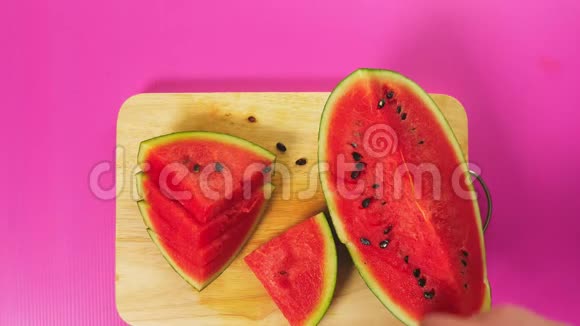 俯视图女手用刀在木板上切水果红色西瓜天然健康食品的概念视频的预览图