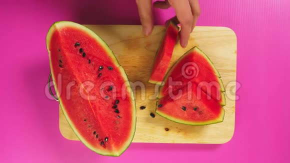 俯视图女手用刀在木板上切水果红色西瓜天然健康食品的概念视频的预览图