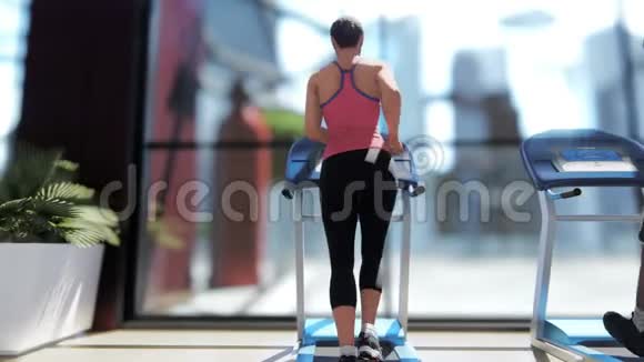 健身房里有各种健身器材人们在阳光明媚的日子里在跑步机上行走视频的预览图
