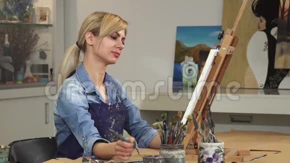 漂亮的年轻女艺术家在艺术工作室创作她的画视频的预览图