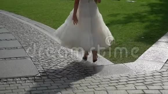 年轻的新娘穿着婚纱在城市里散步白色豪华礼服视频的预览图