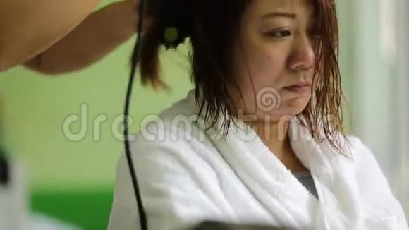 美容院的亚洲女人在吹吹风视频的预览图