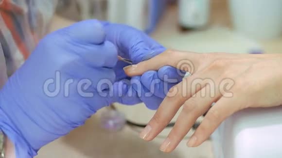 五金美甲特写美甲护理美妇在美容院有清漆的美甲指甲治疗视频的预览图