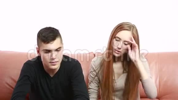一对漂亮的年轻夫妇坐在沙发上争论不开心视频的预览图