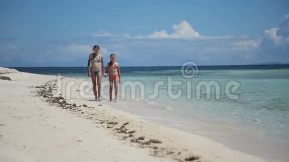 两个女孩在热带海滩散步视频的预览图