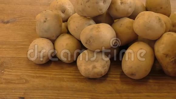 新鲜土豆在乡村木制背景上视频的预览图