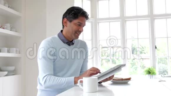 印度男人在吃早餐时使用数码平板视频的预览图