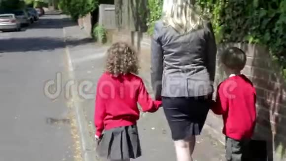 母亲带着孩子在工作途中步行上学视频的预览图