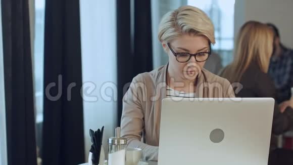 忙碌的年轻女子在咖啡馆里工作视频的预览图