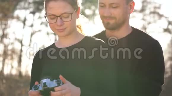 恋爱中的一对年轻夫妇在一台摄像机上拍照视频的预览图