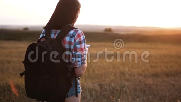 hipsterhiker的剪影女孩走着流浪的背包在手机上搜索位置导航视频的预览图