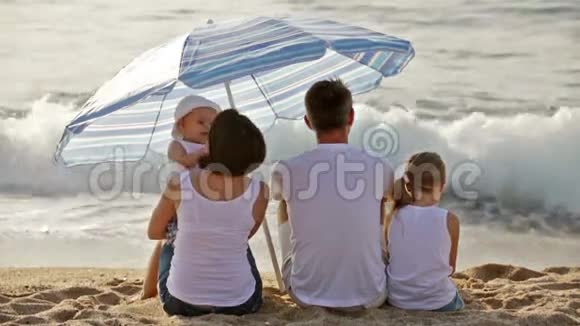 有两个孩子的男人和女人在沙滩上视频的预览图