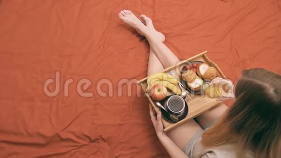 女人躺在床上吃健康的早餐视频的预览图
