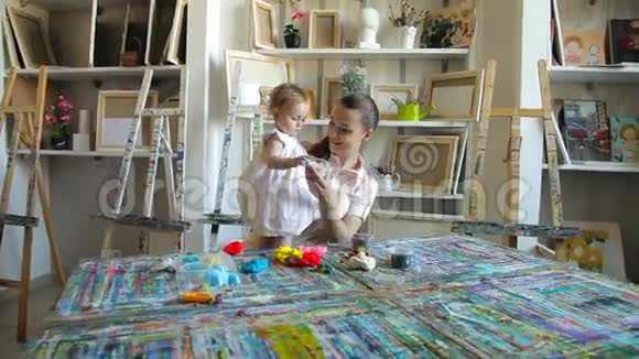 小女孩和妈妈在艺术工作室玩塑料视频的预览图