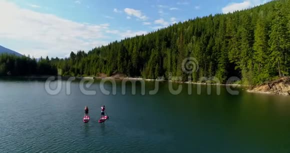 一对夫妇在河里划船一个站起来的桨板视频的预览图