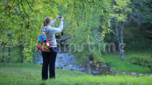 女人拍自然场景的照片视频的预览图
