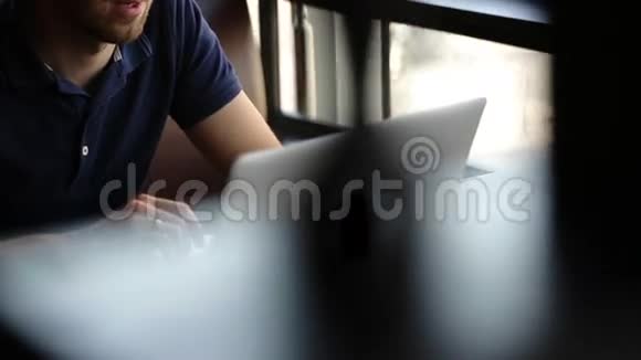 商人坐在咖啡馆里和电脑打交道视频的预览图