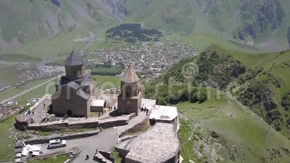 在Kazbegi山下的格鲁吉亚Gergeti村附近的GergetiTrinity教堂的空中景观视频的预览图