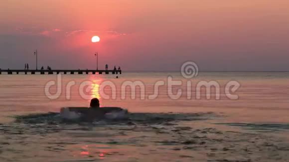 日落时分在海里游泳的人视频的预览图