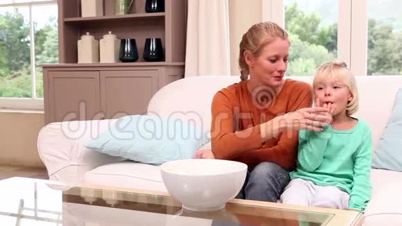 可爱的小女孩和妈妈一起看电视视频的预览图