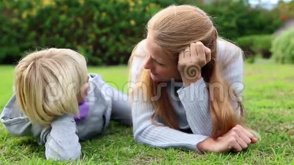 母亲和女儿躺在草地上聊天视频的预览图