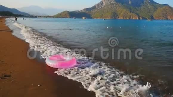 粉红色的充气圈在海滩上视频的预览图