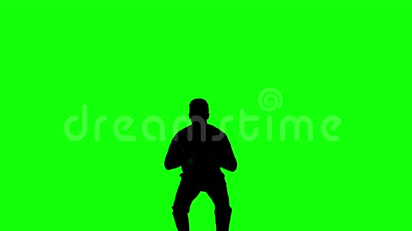 男人用双腿在绿色屏幕上跳跃的剪影视频的预览图