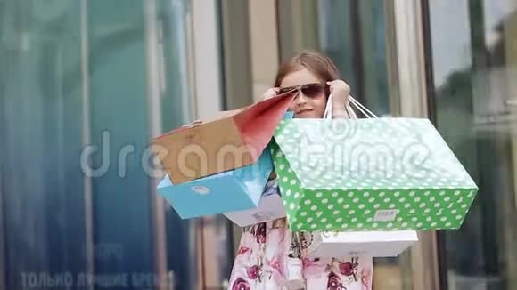 可爱的小女孩在购物一个带购物袋的孩子的肖像购物女孩视频的预览图
