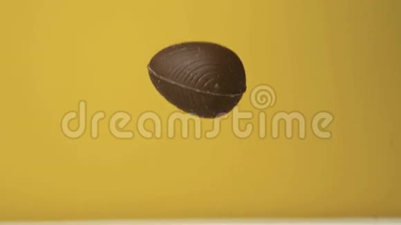 巧克力复活节彩蛋在黄色背景下坠落视频的预览图