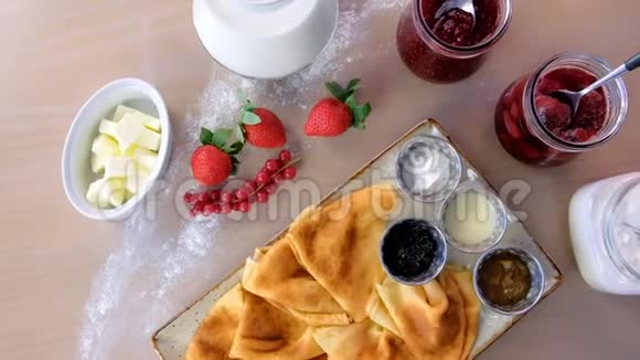 传统的俄罗斯煎饼布莱尼盘子里装满了果酱酸奶油牛奶和草莓视频的预览图