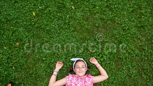 白人少女躺在公园的草地上视频的预览图