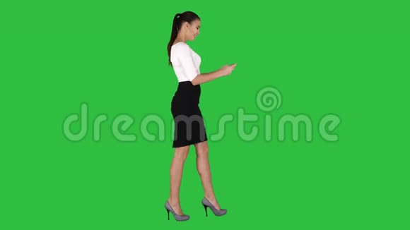 商务女性使用智能手机在绿色屏幕上行走铬键视频的预览图