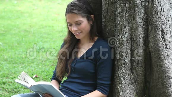 女人坐在树旁看书视频的预览图
